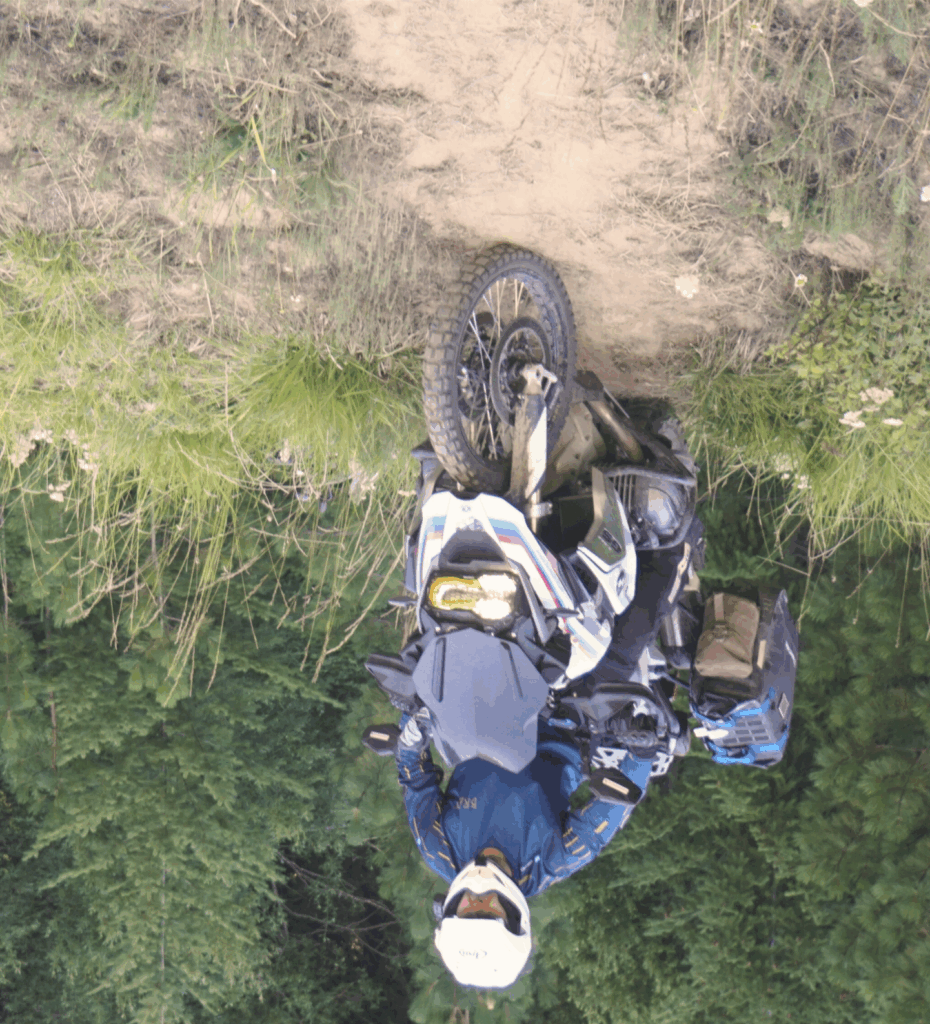Bret Tkacs riding down a steep hill on his BMW R1200GS during Washington adventure training.